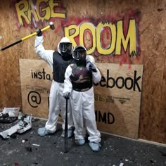 two people dressed in white and black holding baseball bats