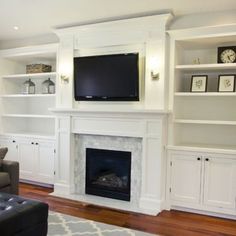 a living room filled with furniture and a flat screen tv mounted on the wall above a fireplace