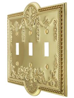 an ornately decorated light switch plate covers the entire wall in this antique brass finish