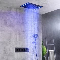 a shower head with blue light coming from it's side in a bathroom setting