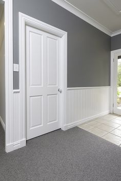 an empty room with gray walls and white trim on the door, carpeted floor