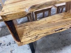 a wooden bench sitting on top of a cement floor