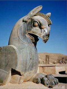 a statue of a horse with its head turned to the side, in front of a desert landscape