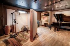 a room with a piano, stools and other musical instruments