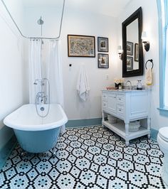 a bath room with a tub a sink and a mirror on the wall in it