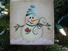 a snowman ornament hanging from a christmas tree