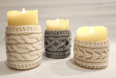 three knitted candles are sitting next to each other