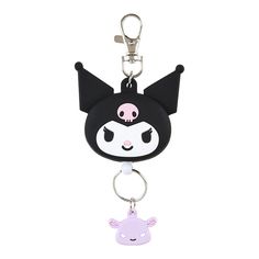 a black and white key chain with a pink skull on the front, and a purple bear on the back