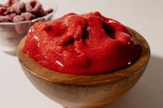 a wooden bowl filled with red colored food