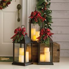 two lanterns with christmas decorations on the front porch