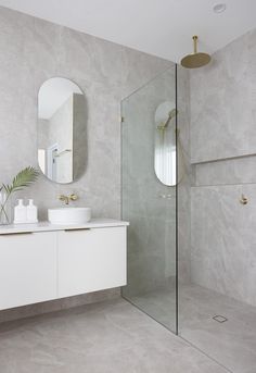 a bathroom with two sinks and a large mirror on the wall next to a walk in shower