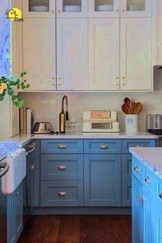 a kitchen with white cabinets and blue counter tops, wood floors and wooden flooring