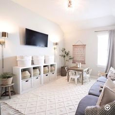 a living room filled with furniture and a flat screen tv mounted to the side of a wall