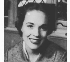 an old black and white photo of a woman smiling