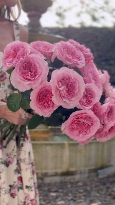 a woman holding a bouquet of pink flowers