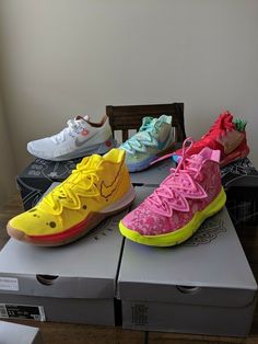 four pairs of nike shoes sitting on top of a box