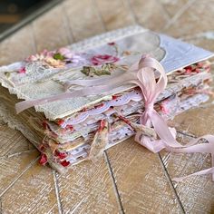 a stack of paper with pink ribbons on top of it