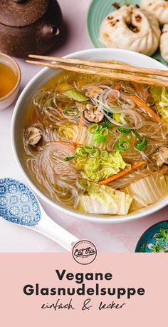 there is a bowl of soup with chopsticks on the table next to it