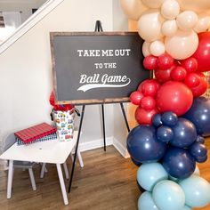 there is a sign that says take me out to the ball game and balloons all around it