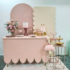 a pink and gold table with flowers on it