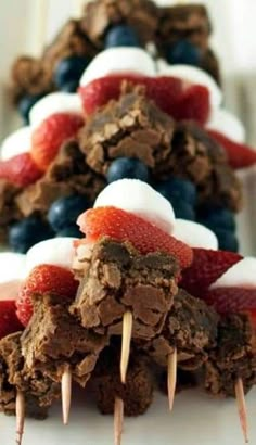 chocolate desserts with strawberries, blueberries and marshmallows on them