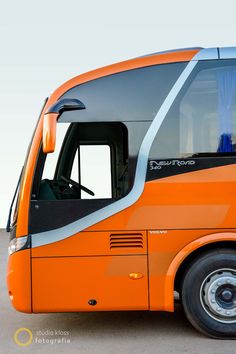 an orange bus is parked on the side of the road with its door open and it's windows partially closed