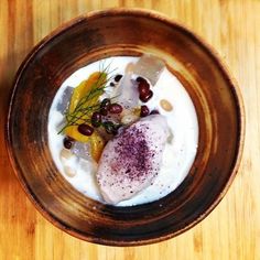 a wooden bowl filled with food on top of a table