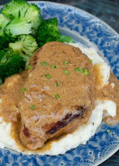 a plate with mashed potatoes, broccoli and gravy on it