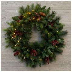 a christmas wreath with lights and pine cones