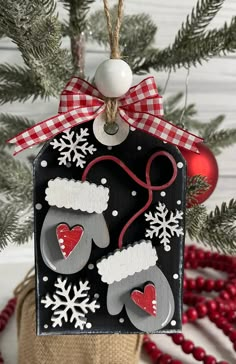 a christmas ornament hanging from a tree with snowflakes and stockings on it