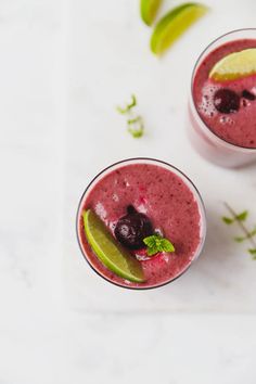 two glasses filled with blueberry and lime smoothie