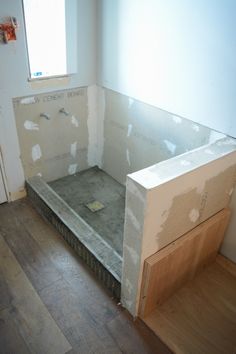 an unfinished bathroom is being remodeled with wood flooring