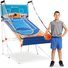 a young boy holding a basketball standing next to an inflatable basketball game set