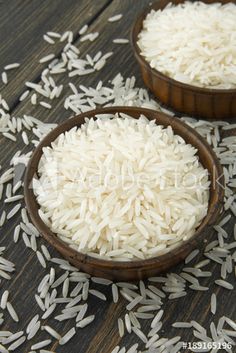 two bowls filled with white rice on top of a wooden table