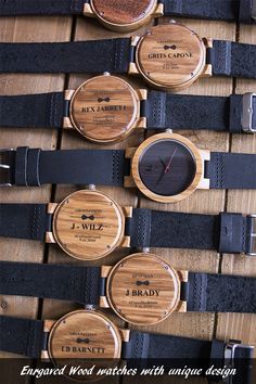 wooden watches with unique designs on them are arranged in a row against a wood background