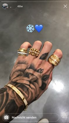 a person's hand with several different rings on it and an image of a snowflake in the background