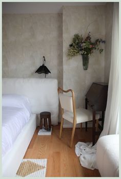 a white bed sitting next to a wooden floor