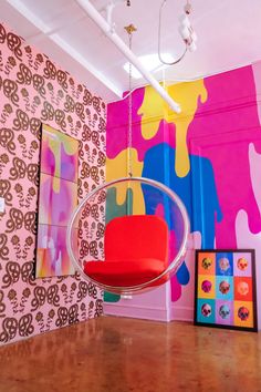 a room with colorful wallpaper and a hanging chair in the middle of the room