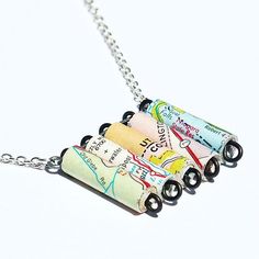 three necklaces made out of rolled up maps