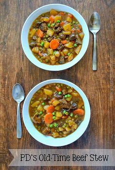 two bowls filled with soup on top of a wooden table