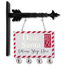 a sign with bells hanging from it's side on a hook that says dear santa please stop here