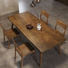 a wooden table with four chairs and a bowl of fruit on the dining room table