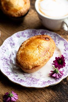 a piece of pie on a plate next to a cup of coffee