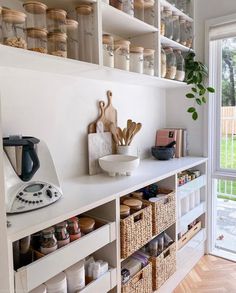 a kitchen with lots of shelves filled with different types of items and utensils