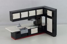 a lego model of a kitchen with white and black cabinets