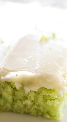 a piece of green cake with white frosting on it's side sitting on a plate