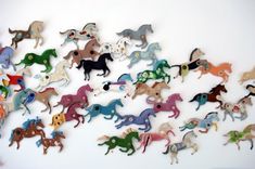 a large group of wooden horses on a white wall