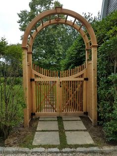 a wooden gate in the middle of a garden