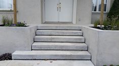 concrete steps lead up to the front door of a house