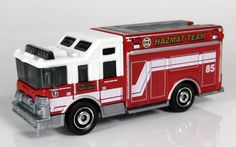 a red and white toy fire truck on a white surface with the words hazmat team painted on it